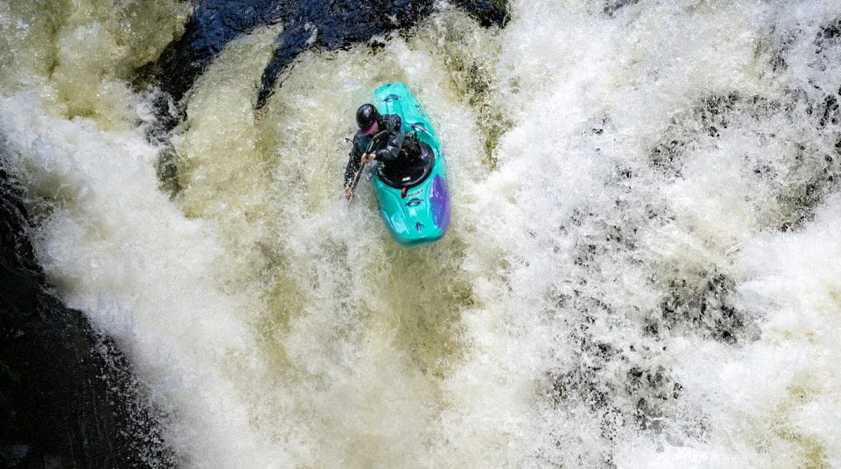 Whitewater kayaker in mountain rapids